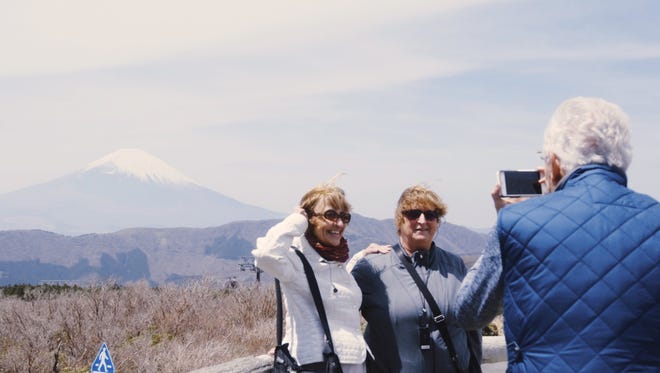 Travelers Janice Boehm and Madonna Carsello pose in front of iconic Mount Fuji.