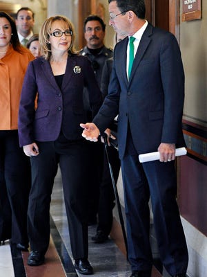 Former Arizona U.S. Rep. Gabby Giffords, left, walks to a meeting at the state Capitol in Hartford, Conn., with Connecticut Gov. Dannel P. Malloy in 2015.