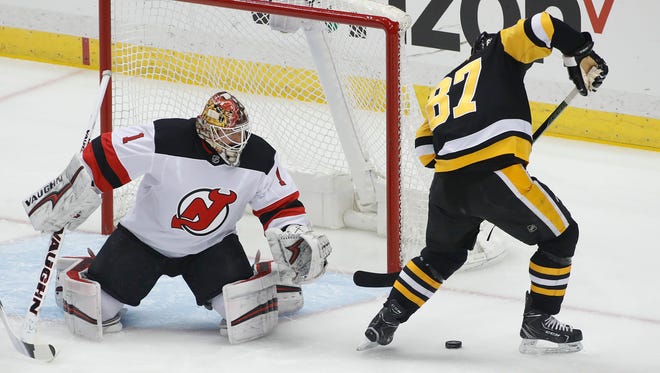 Pittsburgh Penguins' Sidney Crosby (87) works with the puck before scoring on New Jersey Devils goaltender Keith Kinkaid (1) during the first period of an NHL hockey game in Pittsburgh, Friday, March 23, 2018. (AP Photo/Gene J. Puskar)