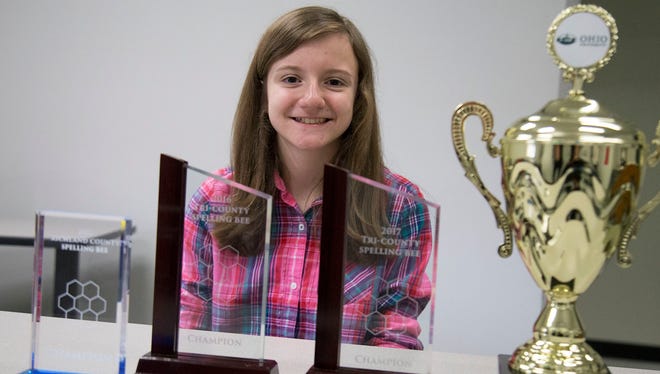 Maggie Sheridan poses with spelling bee trophies that she has won. Sheridan is currently preparing to compete in the national spelling bee. 