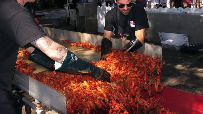Thomas Herter and Phillip Lopez mix in seasonings with the crawfish and try to keep up with the demand during a previous Pensacola Crawfish Festival in Bartram Park. This year's crawfish will be provided by new vendor Cordova Crawfish Company of Pensacola.