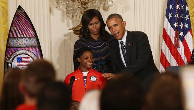 President Barack Obama jokes with gymnast Simone Biles as First Lady Michelle Obama listens at a ceremony honoring the 2016 U.S. Olympic and Paralympic teams in the East Room at the White House on Sept. 29.