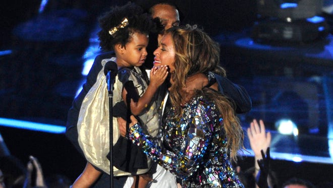 Beyonce on stage hugs Jay Z and their daughter Blue Ivy as she accepts the Video Vanguard Award at the MTV Video Music Awards on Aug. 24, 2014.