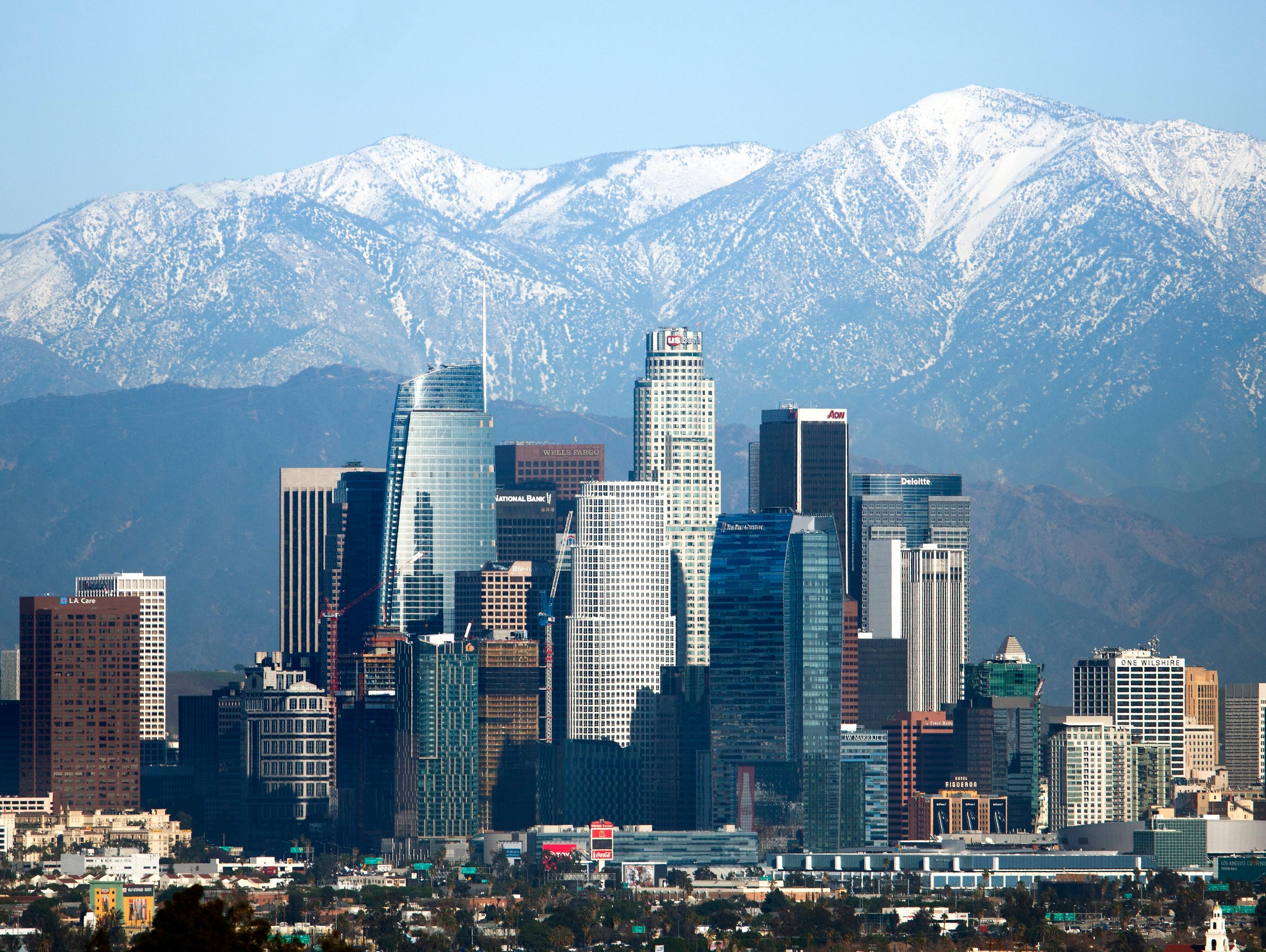 Snow-covered peaks on the San Gabriel mountains from recent storms frame the skyline of Los Angeles on Dec. 27, 2016.