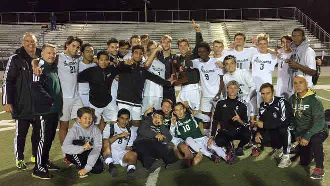Melbourne's boys soccer team poses with its trophy after Friday's District 6-4A championship game.