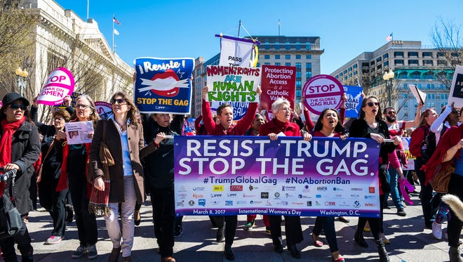 Organizers from CHANGE, the Center for Health and Gender Equality, march along with other protestors to mark International Womens Day during a rally in Washington.