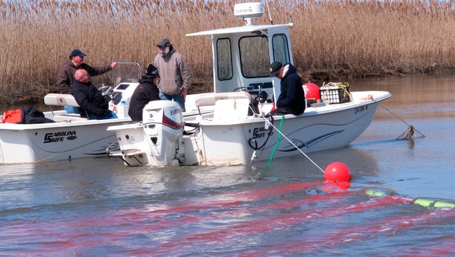 Scientists release red dye into a creek leading into Delaware Bay in Greenwich Township, N.J.