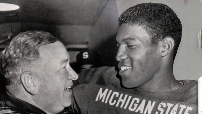 Clinton Jones of Michigan State, right, receives an affectionate pat from coach Duffy Daugherty after Jones broke the Big Ten individual rushing record with 268 yards against Iowa in 1966.