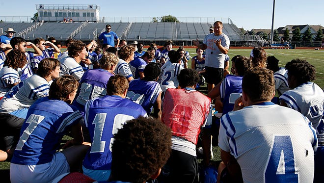 Walled Lake Western coach Mike Zdebski talks to his team a break during their first practice of the season Monday.