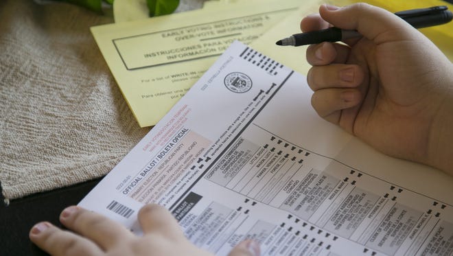 A voter fills out a ballot.