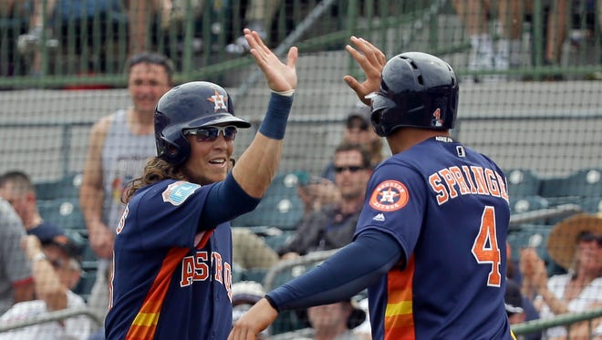 Houston Astros' Colby Rasmus, left, high-fives teammate George Springer (4) as they celebrate Rasmus' home run in the first inning in a spring training baseball game, Friday, March 11, 2016, in Kissimmee, Fla.