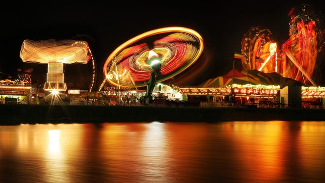 A spinning whirlwind of light from the rides is reflected in the pond of the Agricenter during the Delta Fair & Music Festival on Sept. 10, 2010. This year's fair runs Sept. 1-10.