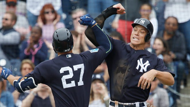 New York Yankees right fielder Giancarlo Stanton (27) and Aaron Judge (right) congratulate each other following Stanton's 2 run home run during the fifth inning against the New York Mets at George M. Steinbrenner Field.