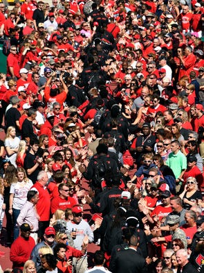 The Louisville Cardinals players are greeted by fans