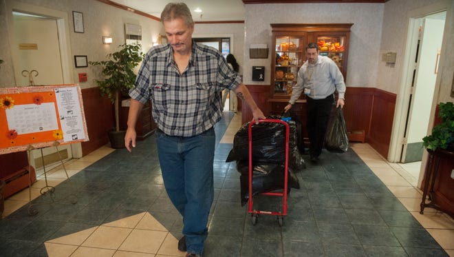 Kenneth, left,  a 47-year-old with end-stage liver disease, is assisted by Bill Nice, intervention specialist with Camden Coalition of Healthcare Providers, as Kenneth moves his belongings out of Sterling Manor in Maple Shade before moving into his new apartment in the Heights of Collingswood.  11.11.15