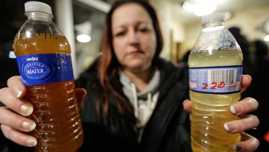 LeeAnne Walters, 36, of Flint, Mich., shows water samples from her home from Jan. 21 and Jan. 15, 2015, after city an state officials spoke during a forum in Flint.