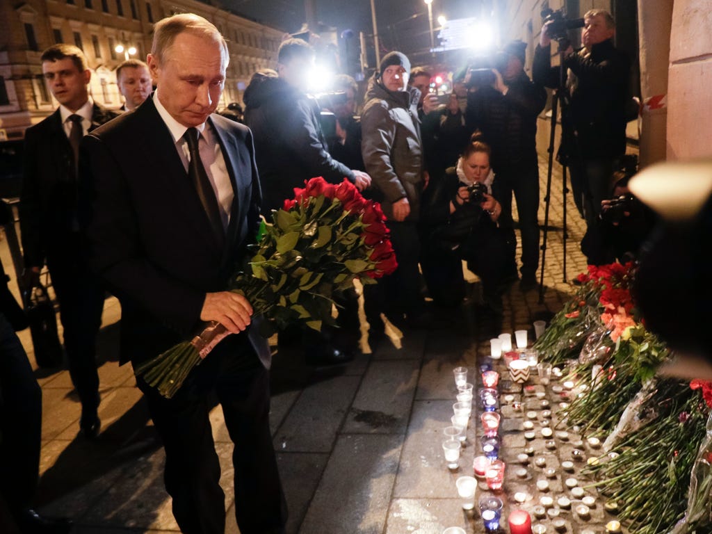 Russian President Vladimir Putin lays flowers near the Tekhnologichesky Institut subway station in St.Petersburg, Russia. A bomb blast tore through a subway train deep under Russia's second-largest city, killing several people and wounding many more 