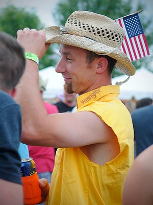 Brian Stommes tips his hat as he stands amongst the crowd at FireFest in July 2015.