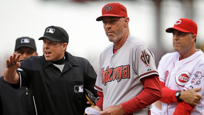 Diamondbacks manager Kirk Gibson (center) and Cincinnati Reds manager Bryan Price (right) listen to home plate umpire Hal Gibson go over the ground rules prior to a game on July 28, 2014, in Cincinnati.