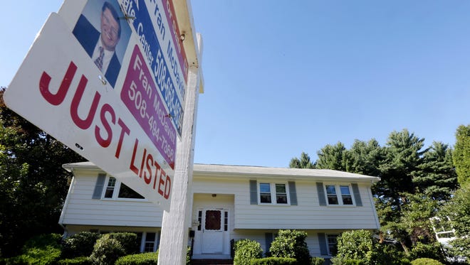A for sale sign hangs in front of a house in Walpole, Mass. A Zillow study shows home values are rose more slowly in the third quarter as the supply of homes for sale increased.