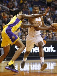 T.J. Warren (right) drives the lane against the Lakers' Brandon Ingram during the first half of Monday's loss.