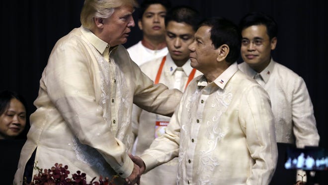 President Trump, left, shakes hands with Philippines President Rodrigo Duterte.