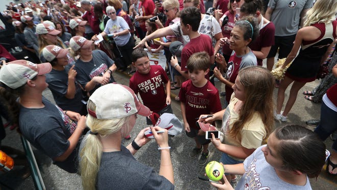 FSU’s Sydney Sherrill signs autographs for fans as they greet the NCAA Softball World Series Champion Seminoles Wednesday after their sweep over Washington in Oklahoma City.