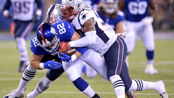 New York Giants tight end Scott Simonson (82) is tackled by New England Patriots linebacker Nicholas Grigsby, left, and linebacker Marquis Flowers during the first half of an NFL preseason football game, Thursday, Aug. 30, 2018, in East Rutherford. (AP Photo/Bill Kostroun)