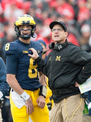 Michigan quarterback John O'Korn and head coach Jim Harbaugh confer during Saturday's game against Ohio State, which ended in a 31-20 Buckeyes' victory.