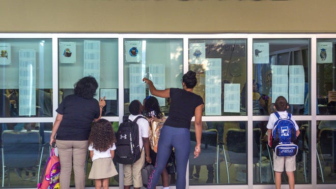 Parents and children look for their class assignments at Pine Jog Elementary in West Palm Beach on the first day of school in August 2018.