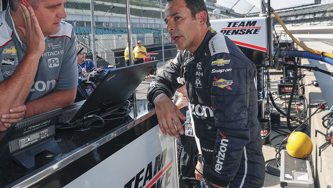 Team Penske's Helio Castroneves talks to a member of his racing team following practice for the IndyCar Grand Prix at the Indianapolis Motor Speedway on Friday, May 11, 2018.