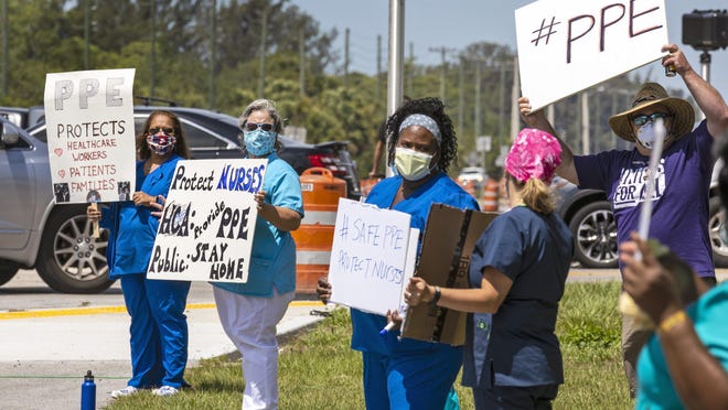 Nurses and other workers demonstrate outside Palms West Hospital in Loxatchee April 23, 2020, calling for better personal protective equipment (PPE) against COVID-19. They say the company loosened PPE protocols which put caregivers, their families and patients at greater risk.