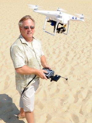 T.J. Redefer a Dewey Beach Real Estate Broker flies one of his drone's with a Hero 3 Camera on the beach in Dewey Beach.