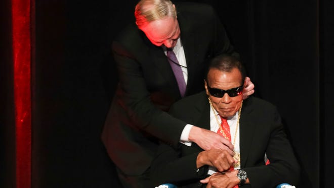 U of L president Dr. James R. Ramsey places the Charles Grawemeyer Spirit Award around the neck of Muhammad Ali to the applause of the crowd in the Louisville Palace on Thursday during U of L's Grawemeyer Spirit Award ceremony. Sept. 17, 2015