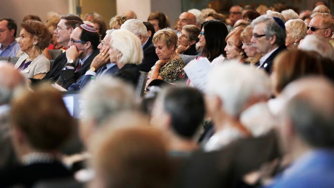 Attendees listen to a presentation during the commemoration service of the 78th anniversary of Kristallnacht "The Night of Broken Glass" at Temple Shalom in Naples on Sunday, Nov. 13, 2016.