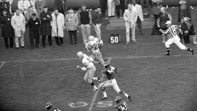 Green Bay Packers halfback Tom Moore (25) heads upfield on a 69-yard run against the Minnesota Vikings at Metropolitan Stadium in Bloomington, Minn., on Oct. 22, 1961.