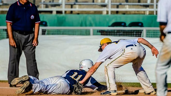 Wyatt Rush, right of Grand Ledge tags out Nolan Knauf,11, of DeWitt as Knauf attempts to get back to 1st for the Panthers' second out in the 5th inning of their Diamond Classic semifinal game Monday at Cooley Law School Stadium in Lansing.