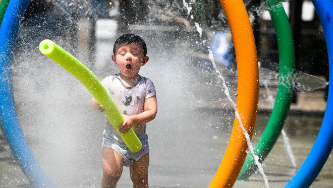 Beating the heat, Gavin Sale, 2 years-old, with noodle in hand, charges through the spray tubes at Henderson's East End Park Sprayground Tuesday, June 19, 2018.