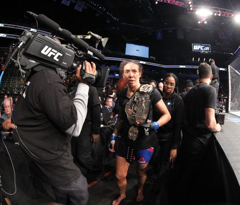 Germaine de Randamie (blue gloves) walks back to the dressing room with the championship belt after defeating Holly Holm (not pictured) during UFC 208 at Barclays Center.