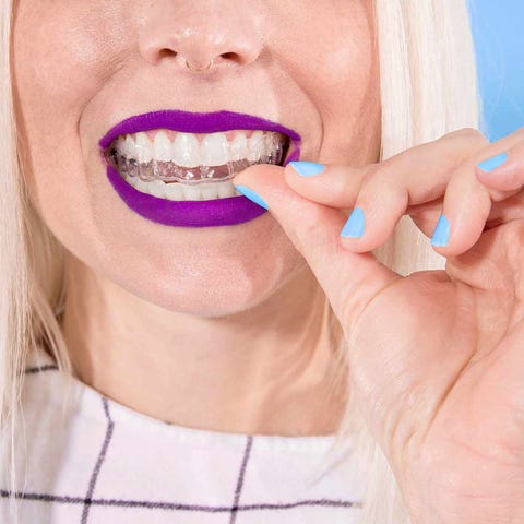 A woman putting on her SmileDirectClub dental alig