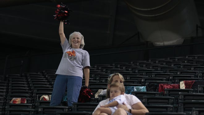 Cindy McBride, known as "the flag lady" at Arizona Diamondbacks games, cheers for the Diamondbacks during their home-stand game against the Los Angeles Dodgers on July 17, 2016. She usually sits in the upper-deck where she can lay her flags out across the seats. She has one for each player in the starting lineup.