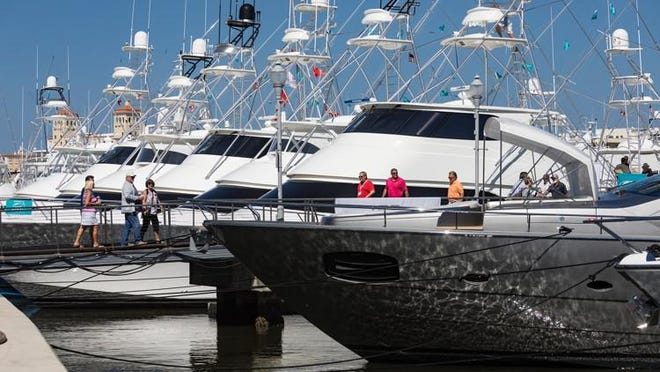 People look at yachts at the Palm Beach International Boat Show in West Palm Beach on March 22, 2018.