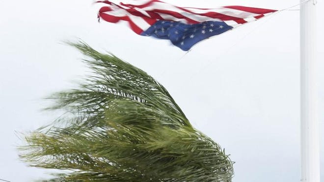 A large flag at a Tequesta wharehouse on Old Dixie blows with the surging winds during Hurricane Irma.