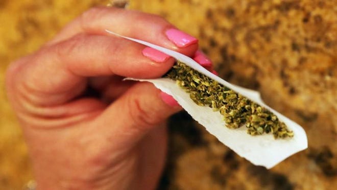 A woman rolls a marijuana cigarette as photographed on August 30, 2014 in Bethpage, New York.