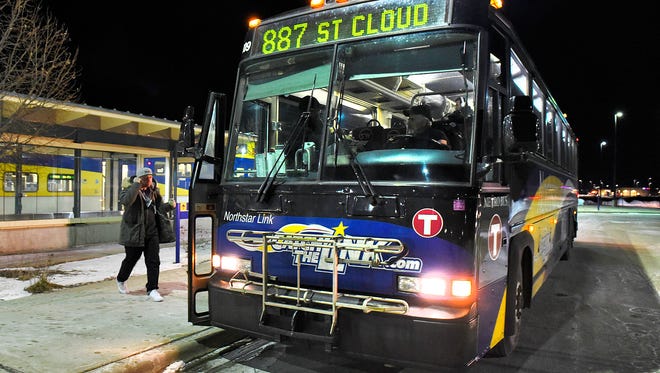 Riders get off the Northstar commuter train at the Big Lake station and board Link buses for the ride to St, Cloud.