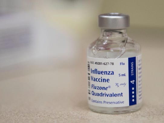 A vial of the flu vaccine sits on a counter at the