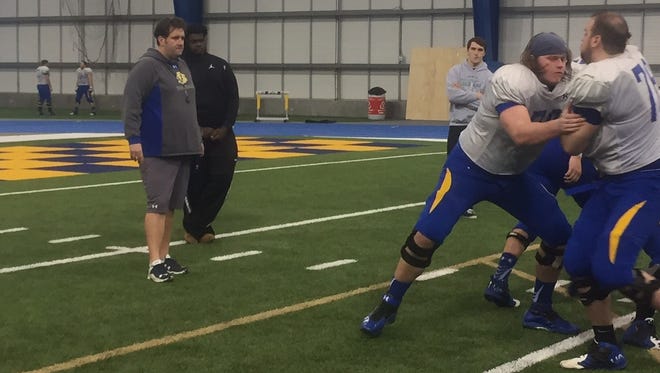 Jason Eck works with SDSU O-linemen last week at the S-JAC