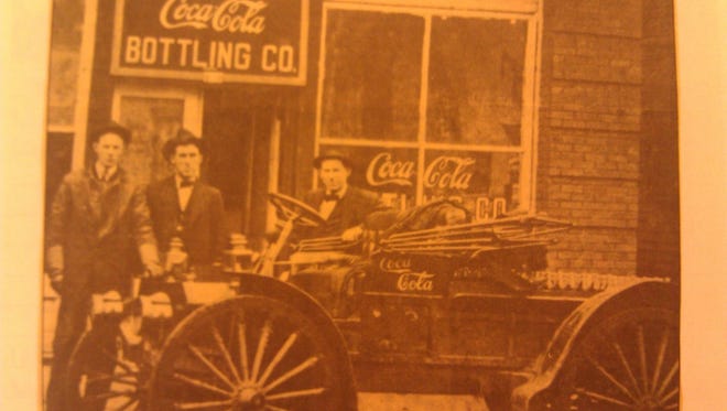 Three Coca-Cola salesmen -- brothers Dick, Oscar and Waller Hembree -- pose beside Anderson's first Coca-Cola delivery truck in 1912.