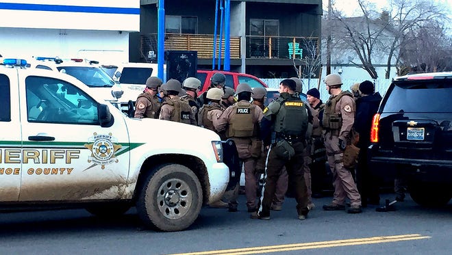 Washoe County deputies and Reno police officers gather at Crampton Street and Wells, where they arrested a wanted man who had barricaded himself in a nearby apartment on Jan. 19, 2017.