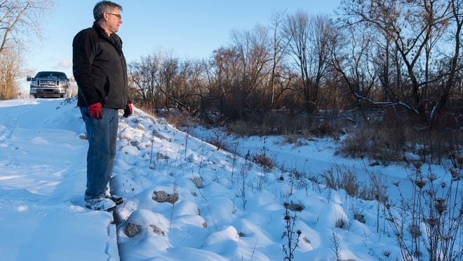 St. Clair County Drain Commissioner Bob Wiley looks over the inlet wier of a wetland in Fort Gratiot Township Dec. 27.